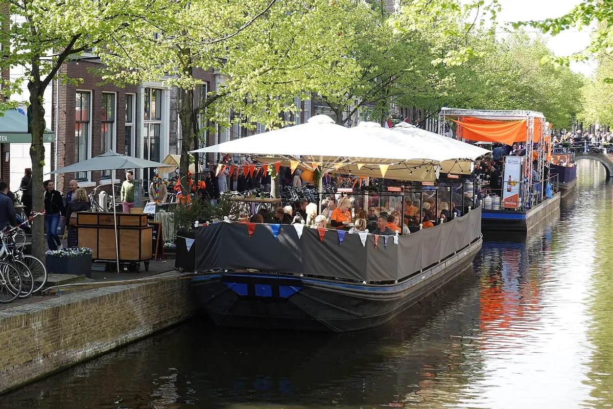 Een vol terras aan een gracht in het centrum van Delft