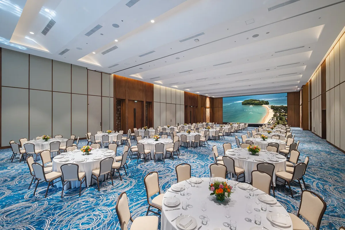 Grote zaal met ronde gedekte tafels voor een diner