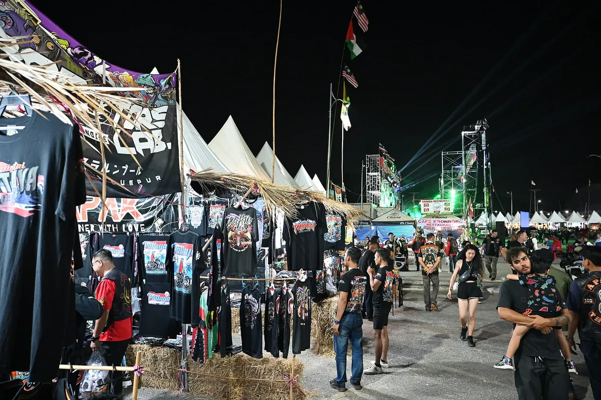 Festivalterrein met kramen en bezoekers in de avond