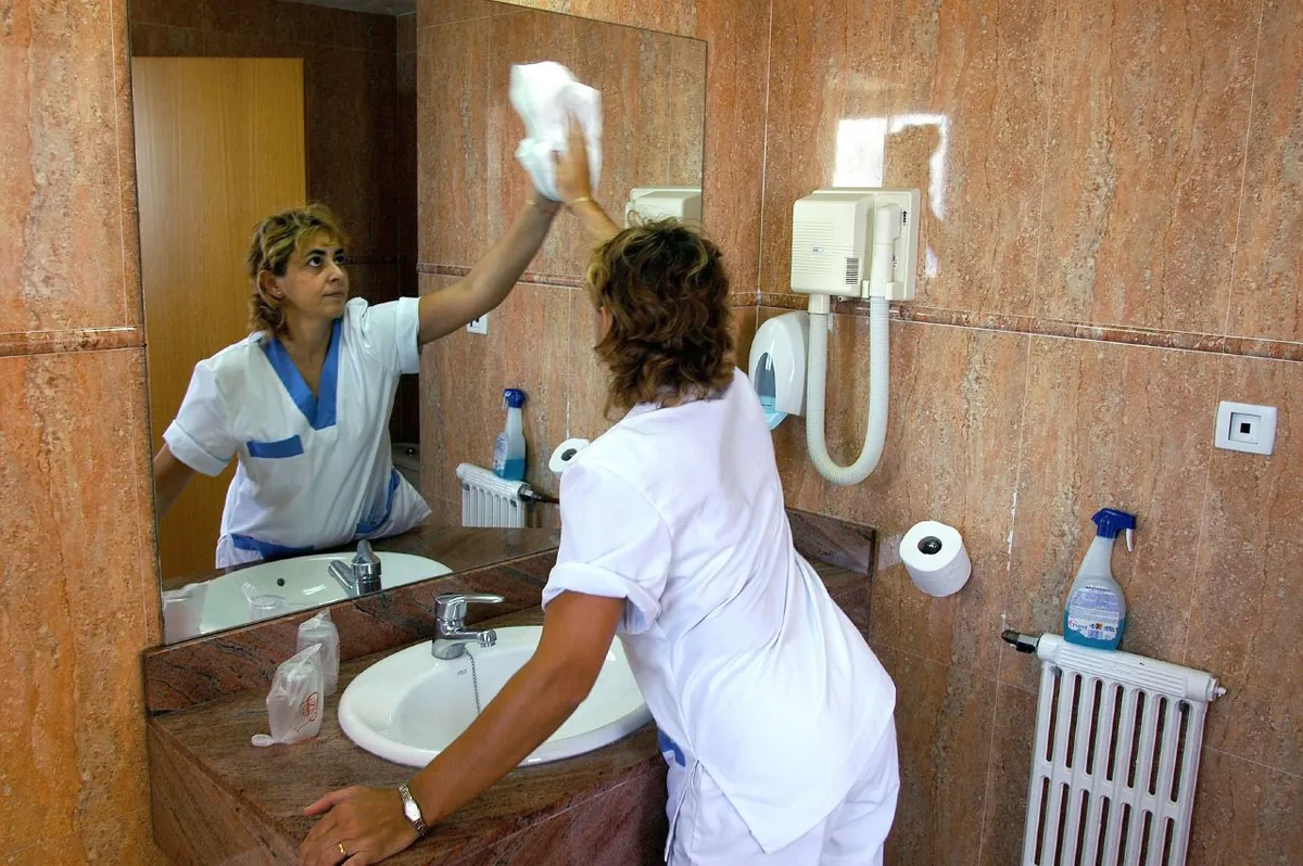 Housekeepingmedewerker maakt een hotelbadkamer schoon